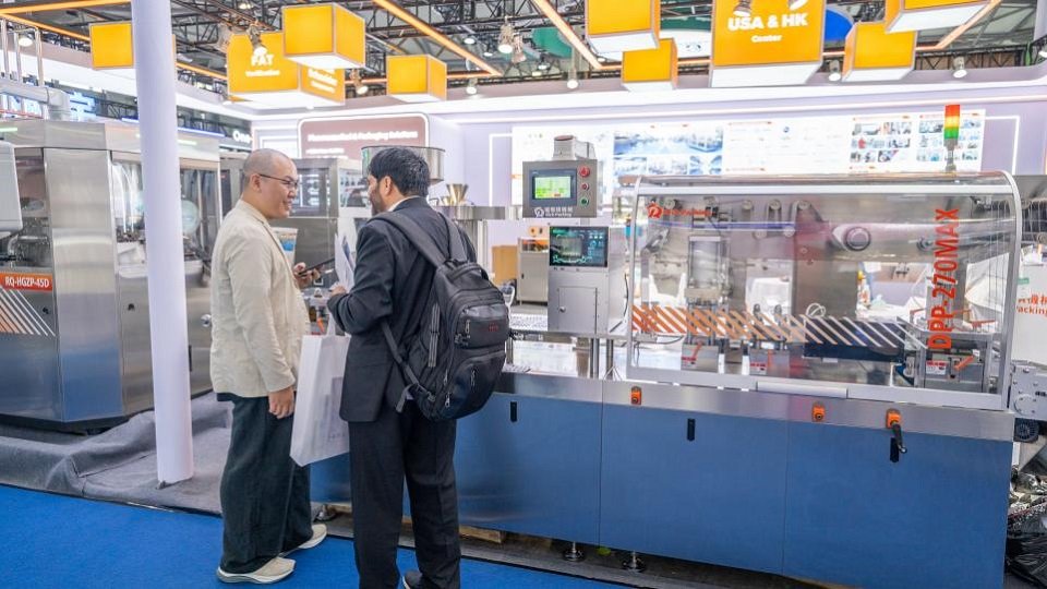 Rich Packing staff introducing DPP-270 Max blister packaging machine to visitor