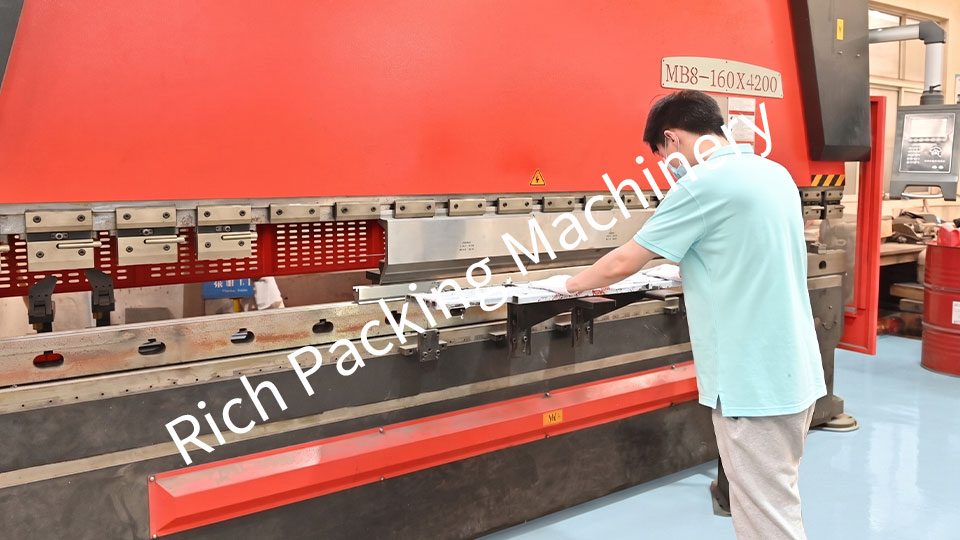 An engineer is operating a metal bending machine